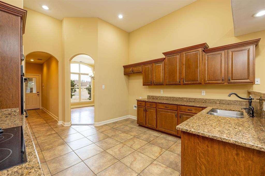 5380 Scarlet Ridge Drive Arlington, TN 38002 - Photo 14 of 35 Kitchen featuring vaulted ceilings, recessed lighting, wood-finish cabinetry, stone countertops, and tile flooring