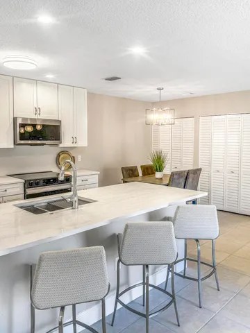 a kitchen with a table chairs sink and cabinets