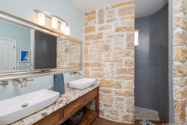 a bathroom with a granite countertop sink and a mirror