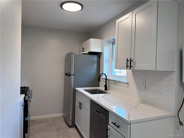 a kitchen with stainless steel appliances granite countertop a sink and a refrigerator