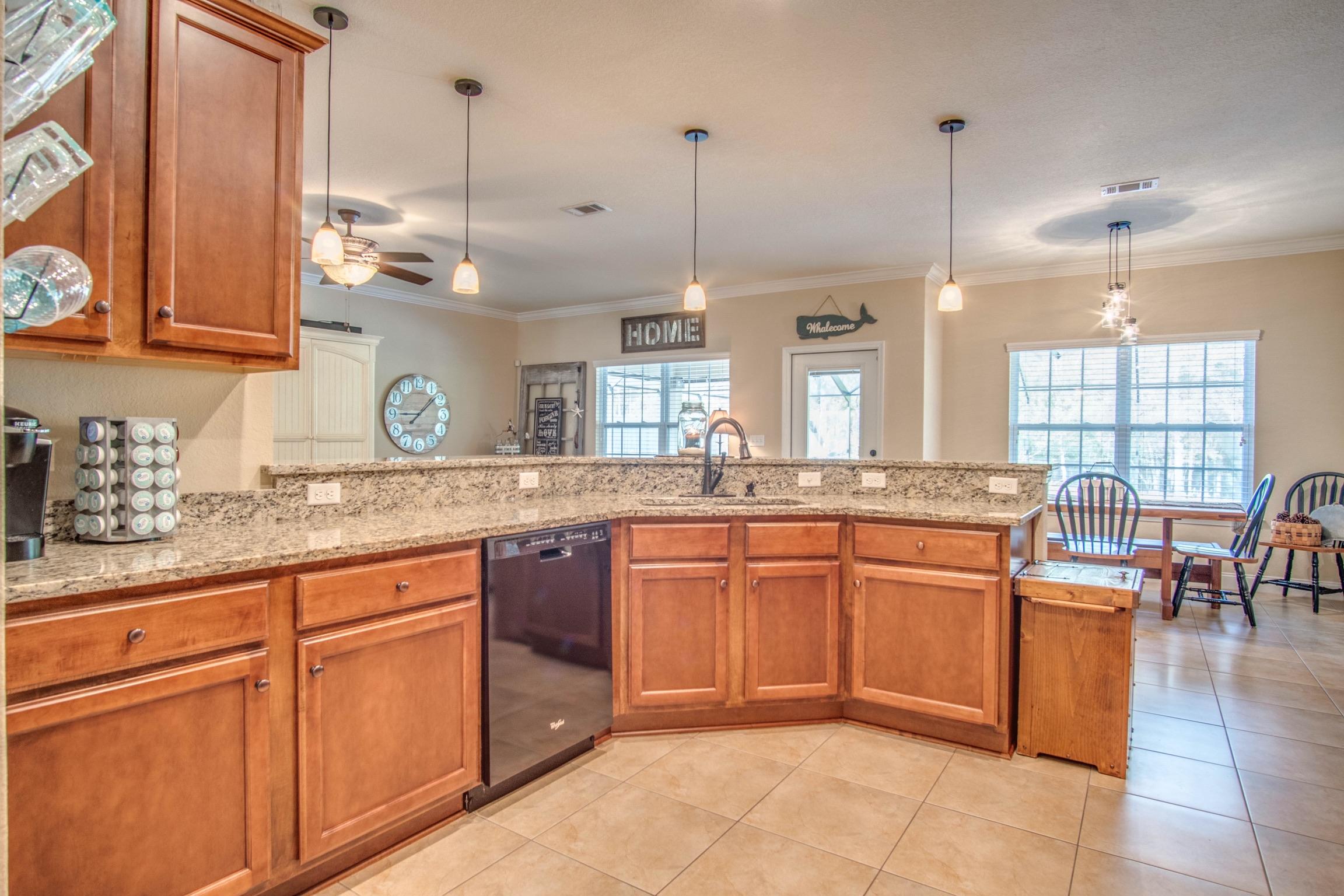 6314 Possum Ridge Road Crestview, FL 32539 - Photo 10 of 47 a kitchen with stainless steel appliances granite countertop a sink a stove and a wooden floors