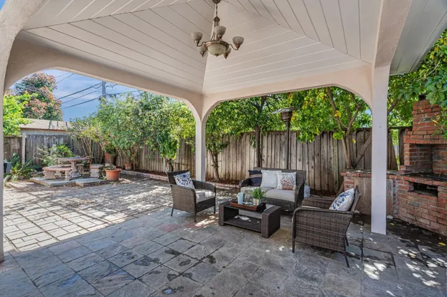 a view of a patio with table and chairs under an umbrella