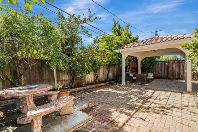 a view of yard with table and chairs and wooden fence
