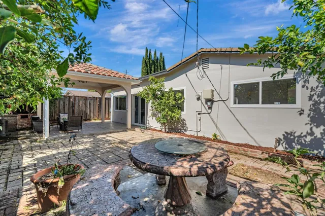 a backyard of a house with table and chairs