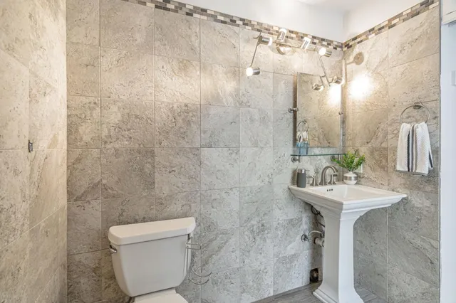 a bathroom with a sink a toilet and shower