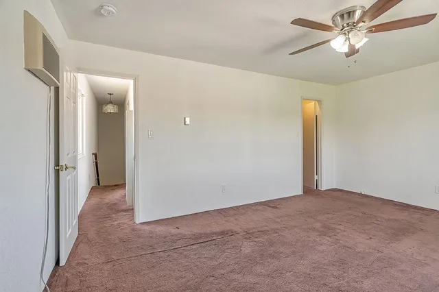 a view of an empty room with a ceiling fan