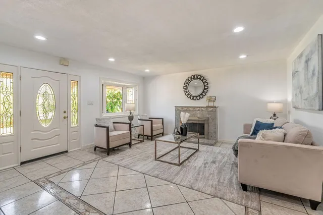 a living room with furniture a fireplace and a chandelier