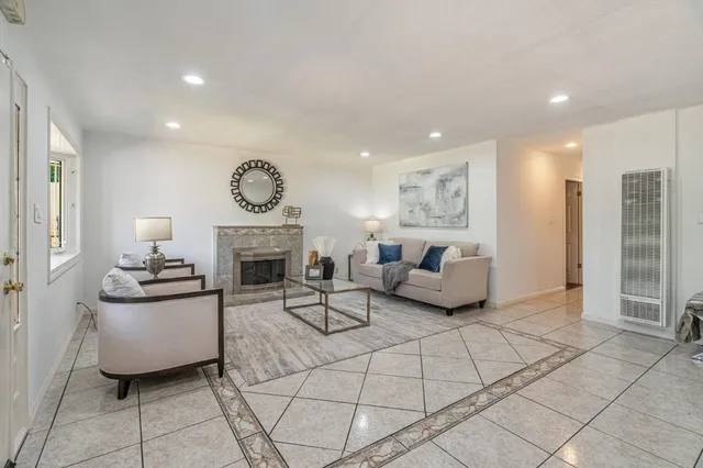 a living room with furniture a fireplace and a open kitchen view