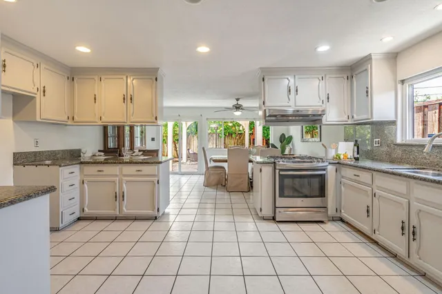 a kitchen with a sink a stove cabinets and stainless steel appliances