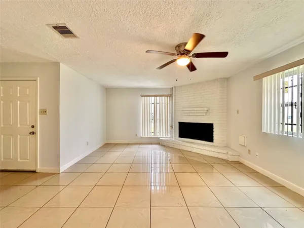 a view of an empty room with a fireplace and a window