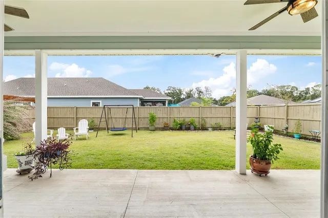 a aerial view of a house with swimming pool and next to a yard