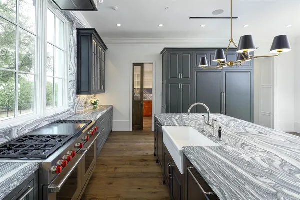a kitchen with kitchen island a sink stove and wooden floor