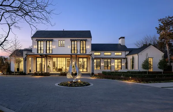 a front view of a house with trees and garage