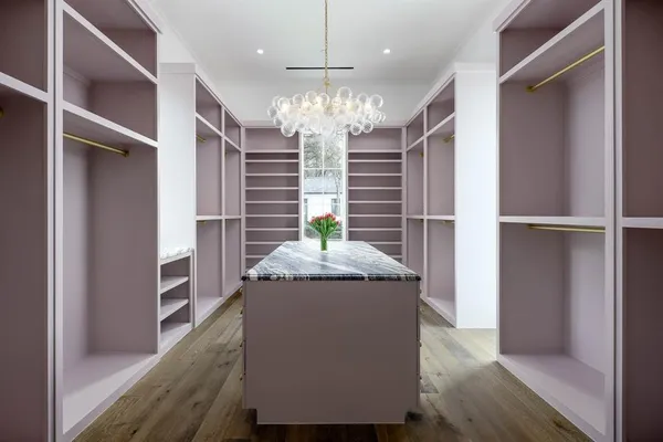 a kitchen with kitchen island stainless steel appliances a chandelier