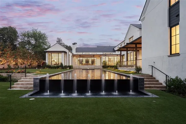 a view of house with swimming pool and yard