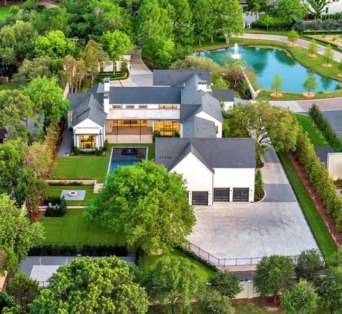 an aerial view of a house with a garden and lake view