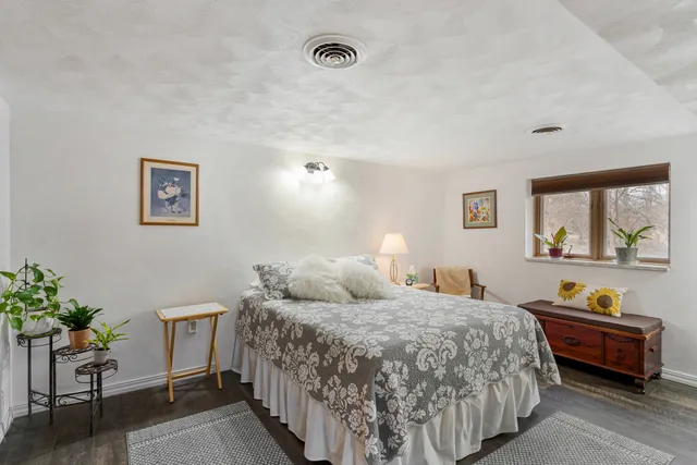 a bedroom with a bed and a potted plant