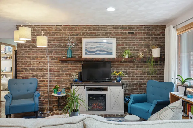 a living room with furniture a flat screen tv and a fireplace