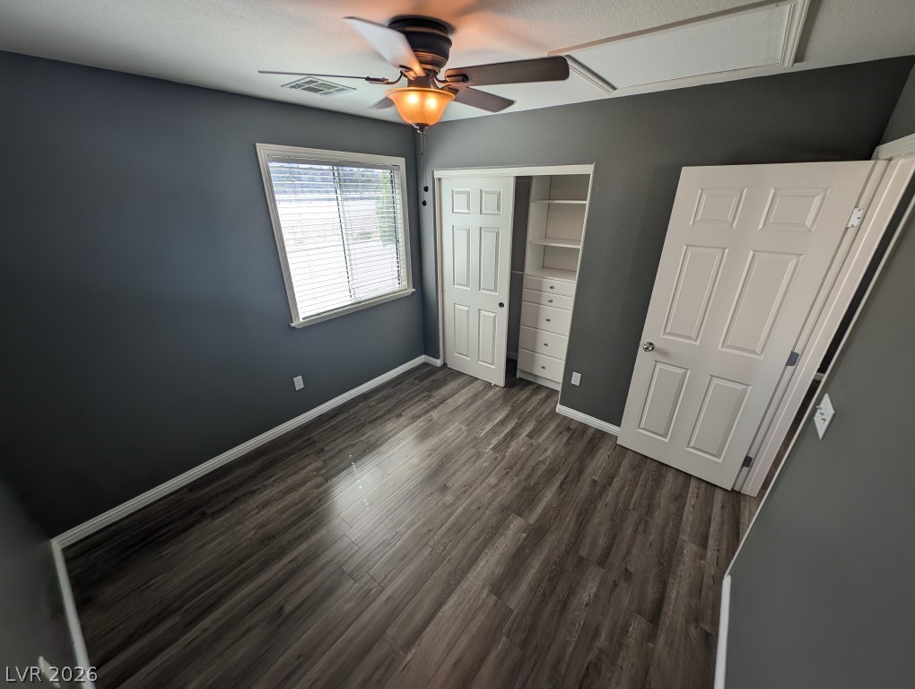 9121 Spoonbill Ridge Place Las Vegas, NV 89143 - Photo 19 of 26 Well-lit sleeping quarters with rich wood-look flooring and custom closet built-ins.