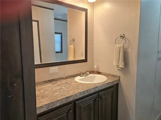a bathroom with a granite countertop sink and a mirror