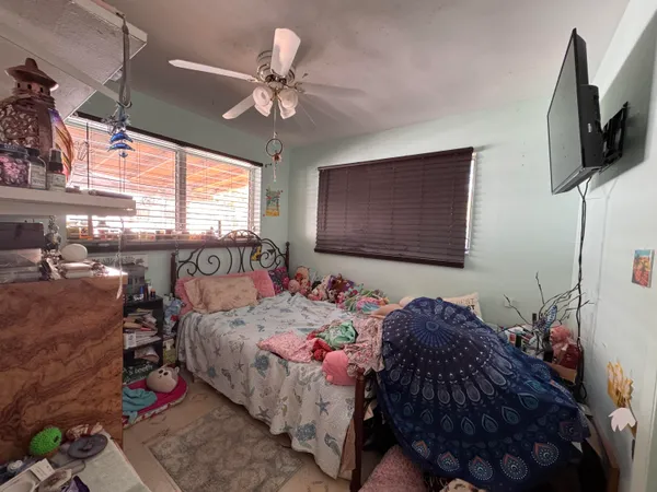 a bedroom with a bed window and flat screen tv