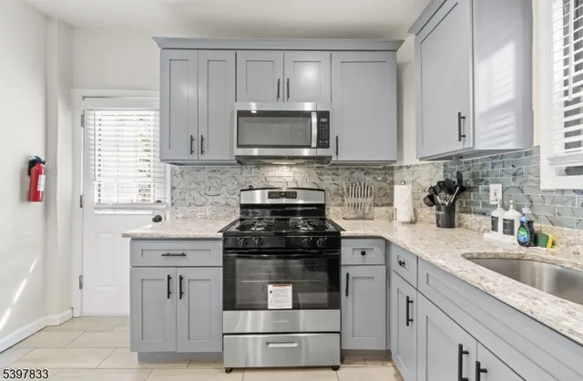 a kitchen with cabinets appliances a sink and a window