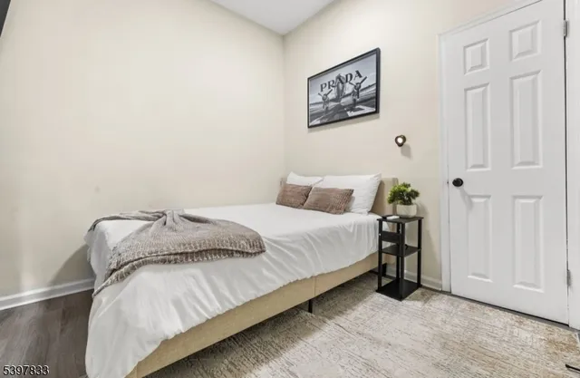 a bedroom with a bed and a painting on the wall