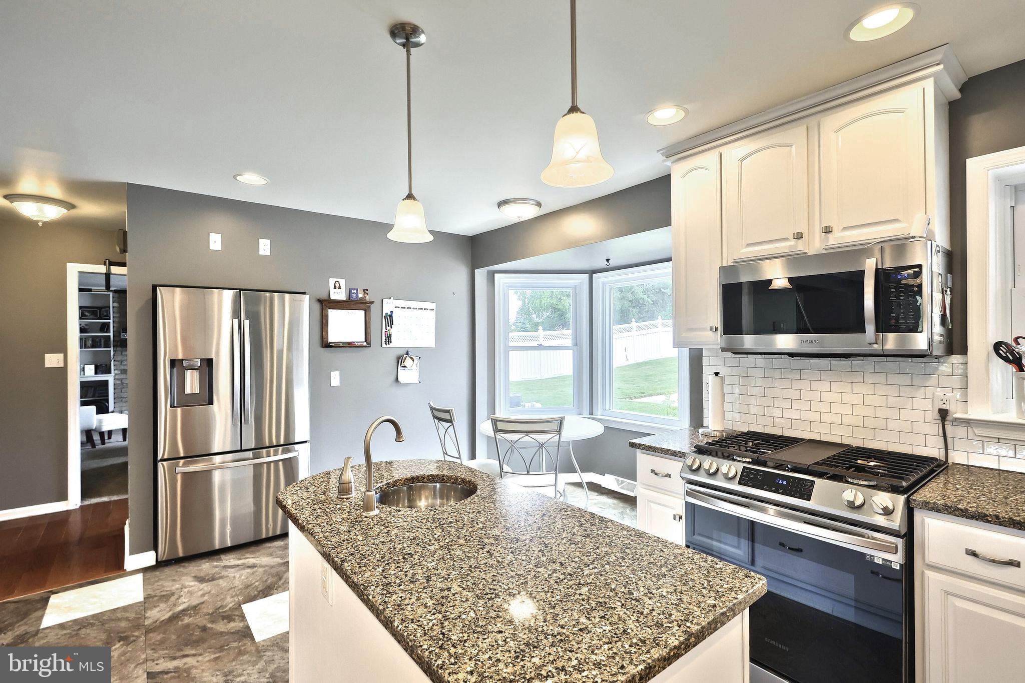 2420 Sutton Road York, PA 17403 - Photo 11 of 49 a kitchen with stainless steel appliances granite countertop a stove refrigerator and microwave