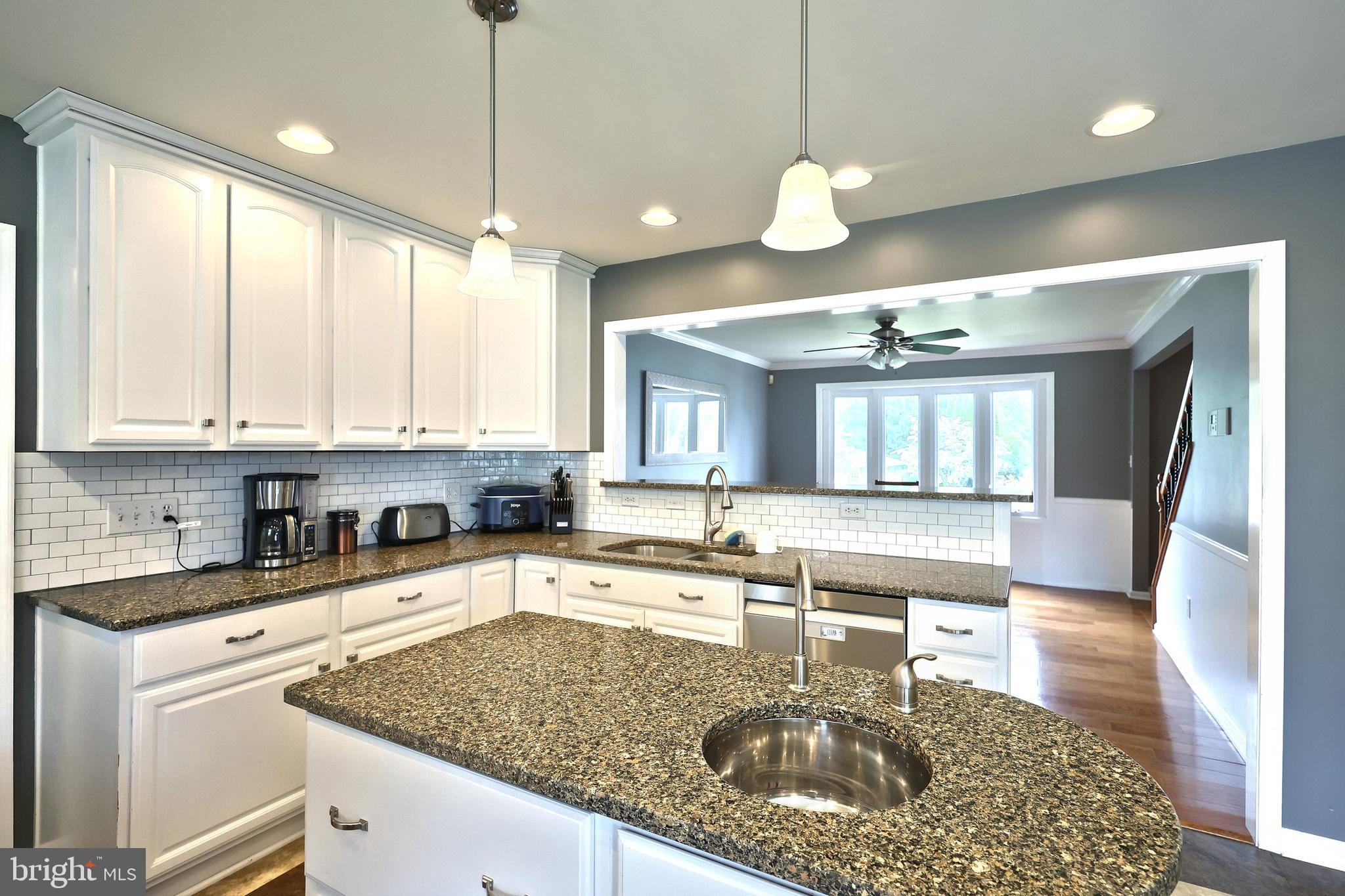 2420 Sutton Road York, PA 17403 - Photo 12 of 49 a kitchen with a stove a sink a center island a dining table and chairs