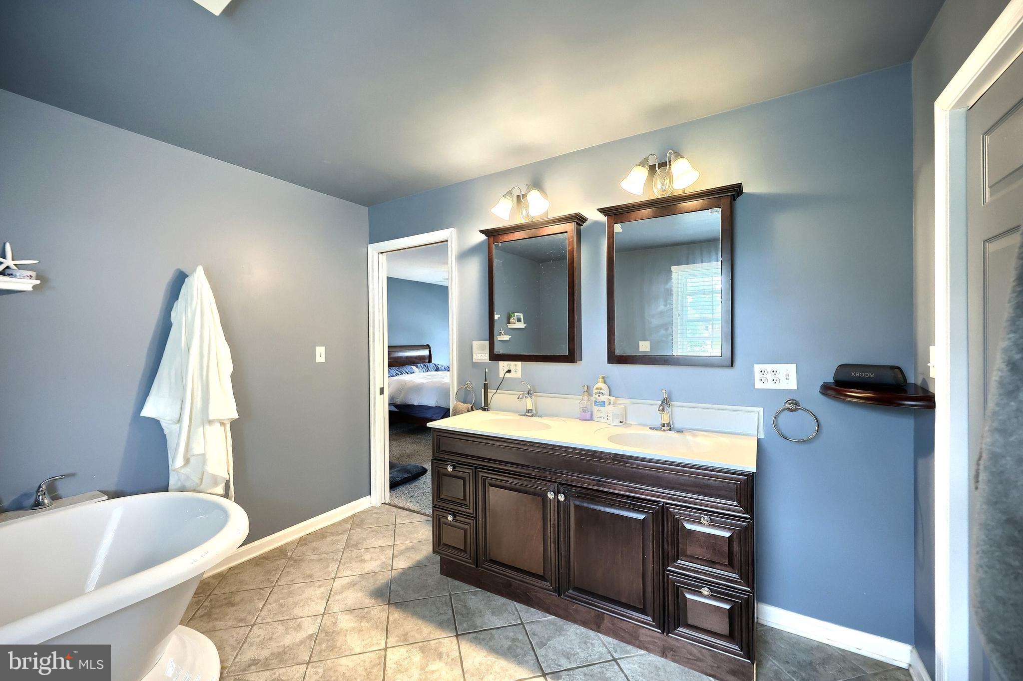 2420 Sutton Road York, PA 17403 - Photo 25 of 49 a spacious bathroom with a bathtub sink double vanity and mirror