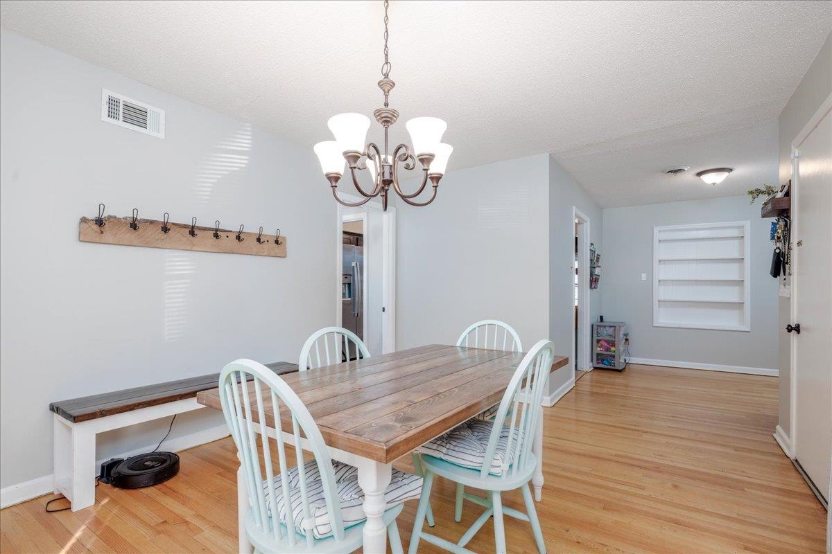 1660 Raymore Road Memphis, TN 38117 - Photo 12 of 30 Dining area featuring a chandelier, built in features, wood-type flooring, and a textured ceiling
