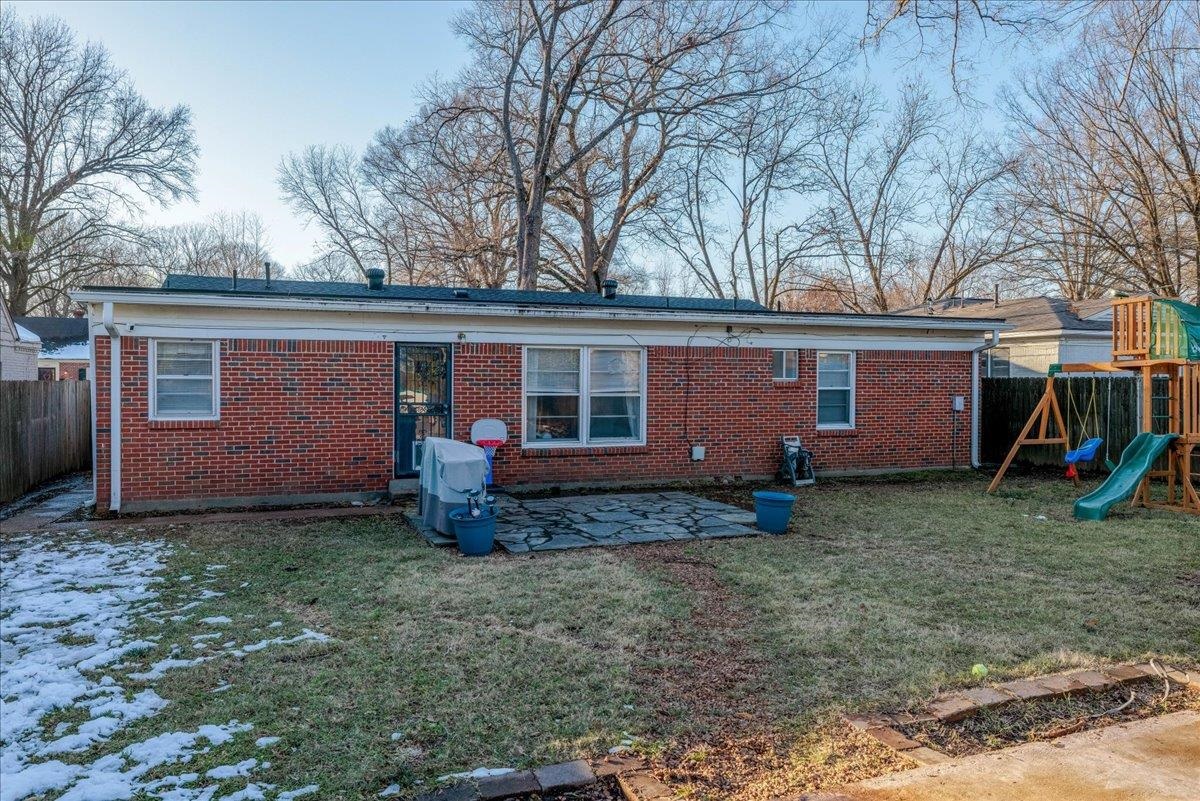 1660 Raymore Road Memphis, TN 38117 - Photo 28 of 30 Rear view of house featuring a playground, a patio area, and a lawn