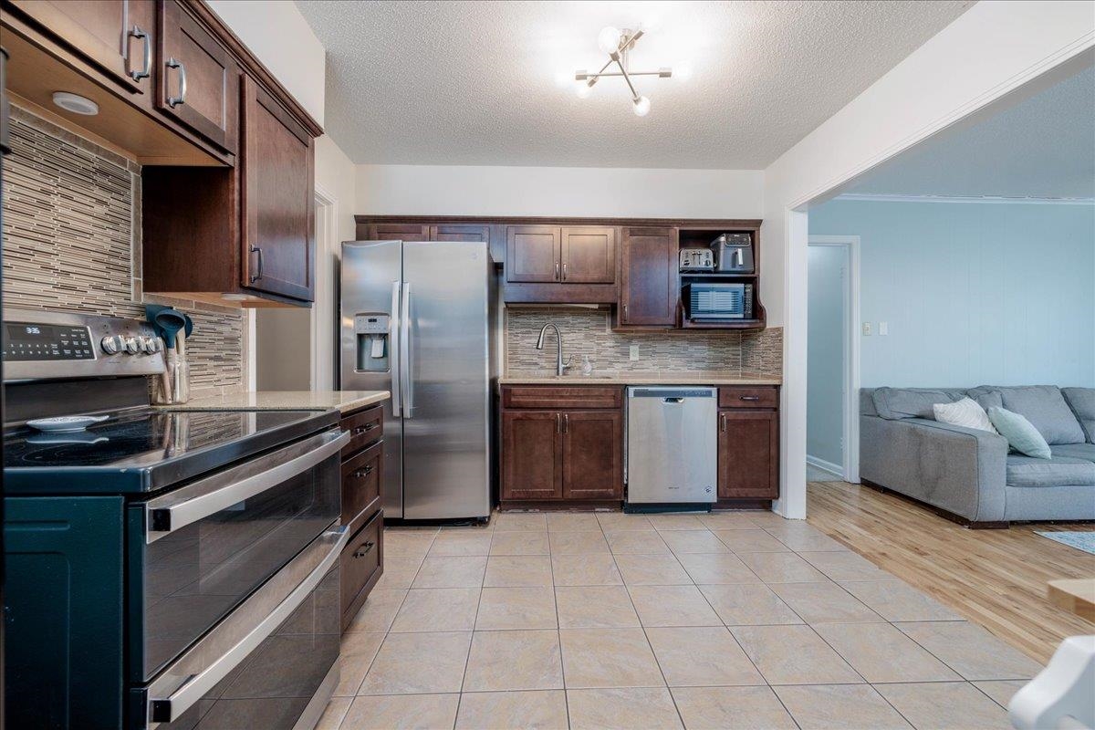 1660 Raymore Road Memphis, TN 38117 - Photo 8 of 30 Kitchen featuring decorative backsplash, sink, light tile patterned flooring, and appliances with stainless steel finishes