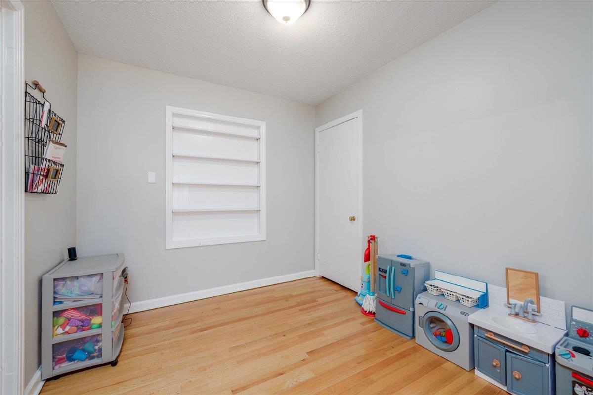 1660 Raymore Road Memphis, TN 38117 - Photo 10 of 30 Recreation room featuring sink, light wood-type flooring, and a textured ceiling