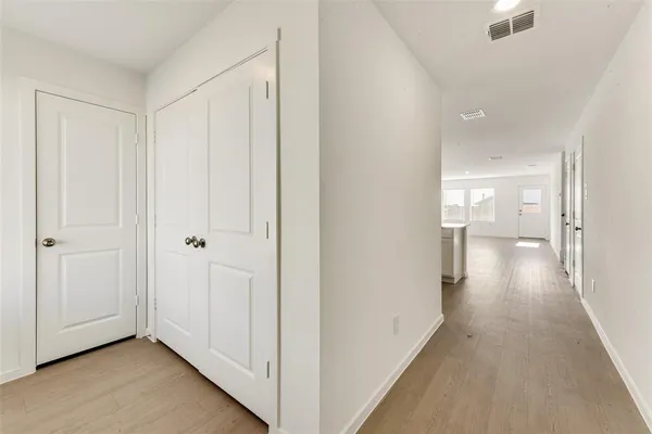 a view of a hallway with wooden floor