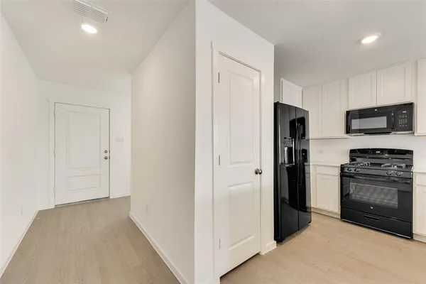 a view of a kitchen with a sink and a refrigerator