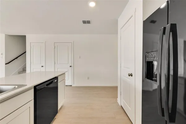 a view of a kitchen with a sink and refrigerator