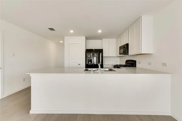a view of kitchen with stainless steel appliances cabinets