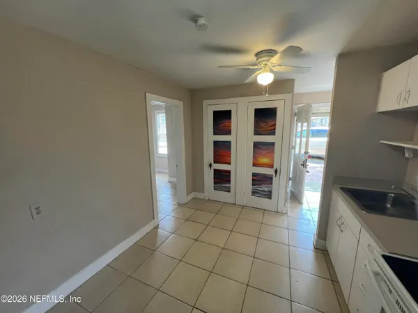 a view of an empty room with window and cabinet