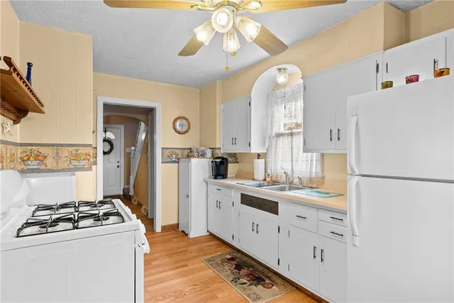 a kitchen with white cabinets and white appliances