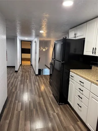 a kitchen with wooden floors and refrigerator