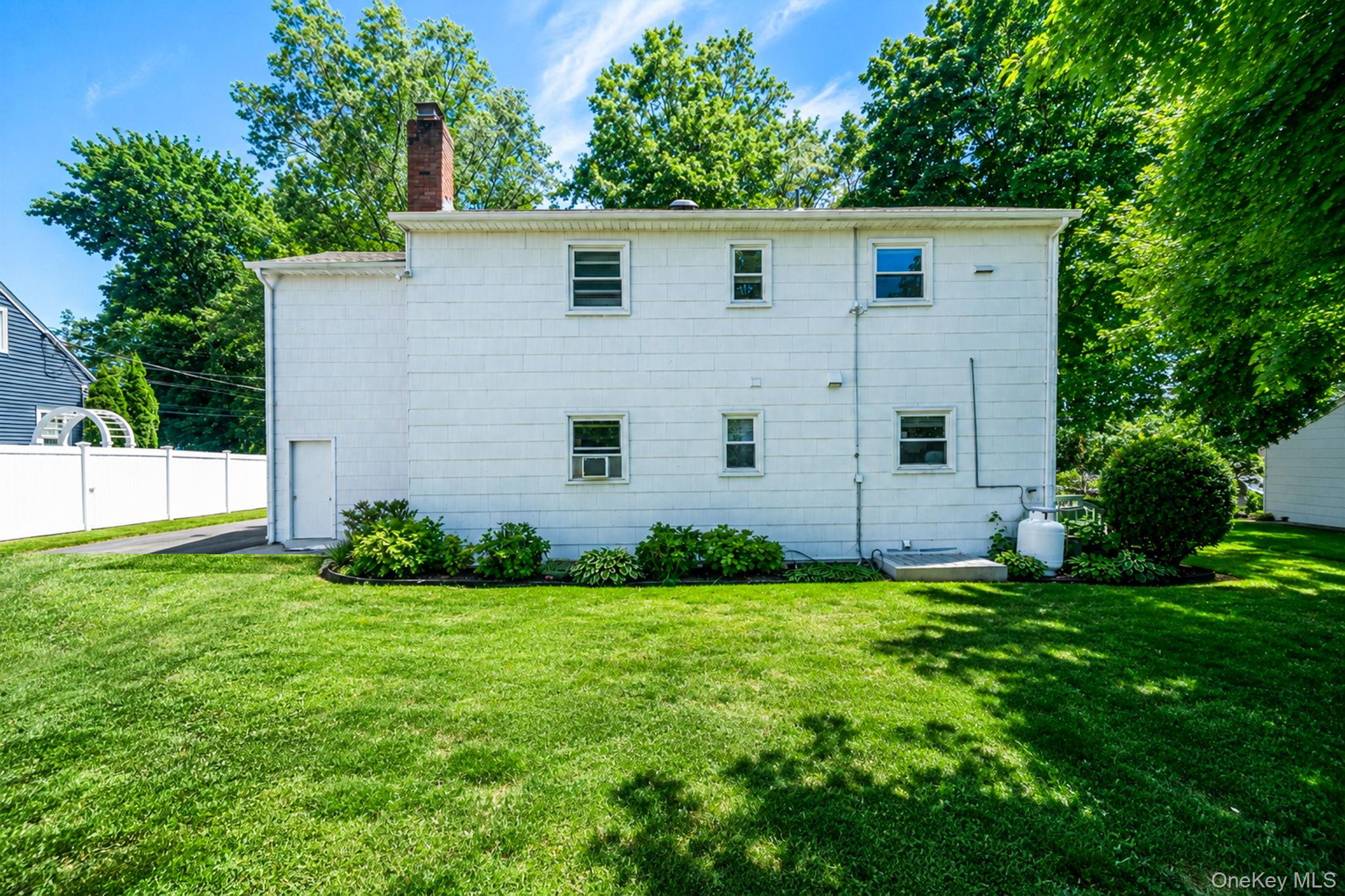 31 Crooked Hill Road Huntington, NY 11743 - Photo 31 of 32 White shingle exterior with multiple windows and a red brick chimney