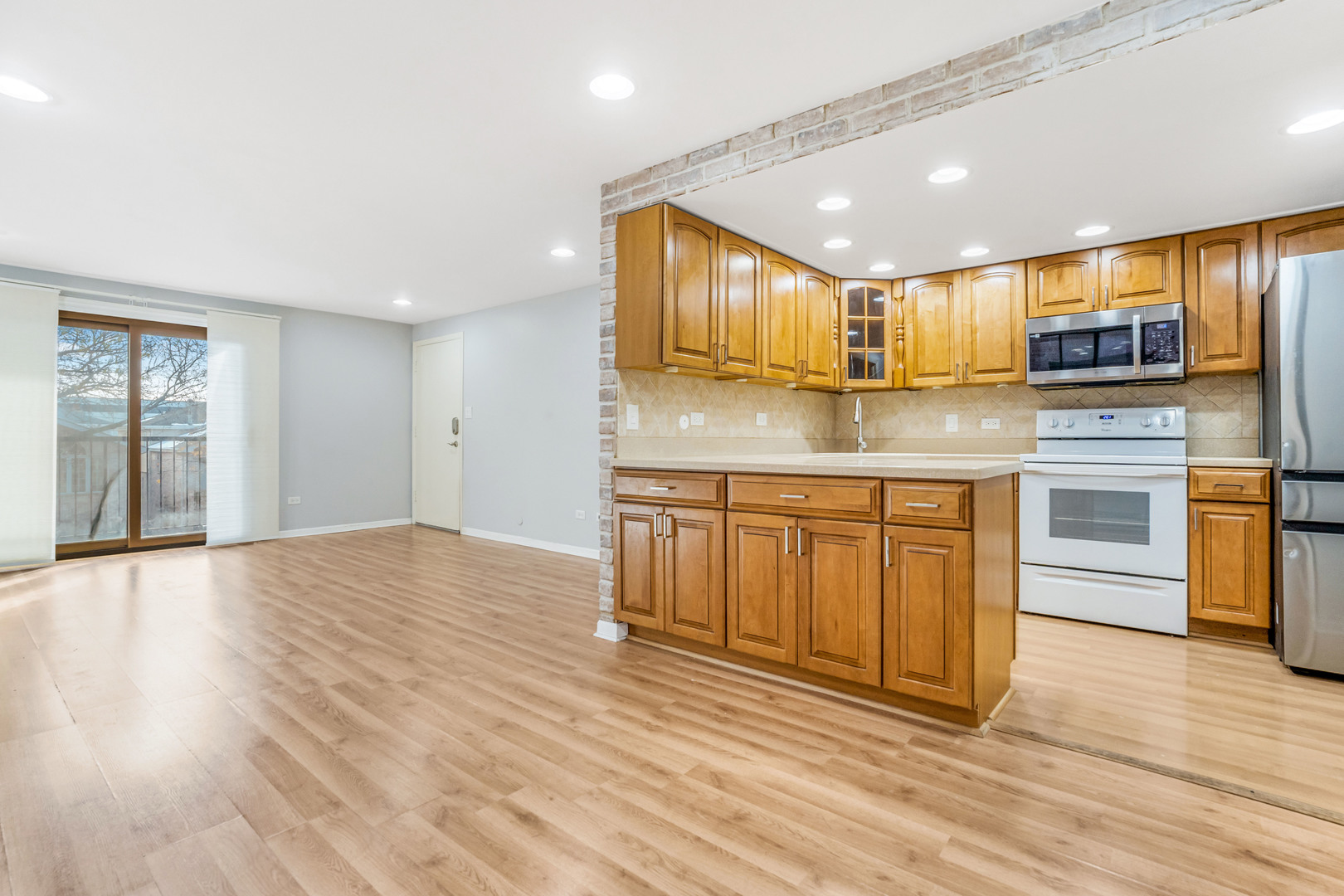 6728 West 64th Place, Unit 2B Chicago, IL 60638 - Photo 6 of 14 a kitchen with kitchen island granite countertop wooden floors stainless steel appliances and sink