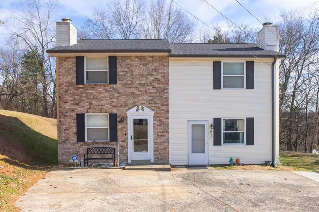 a house that has a large tree in front of it