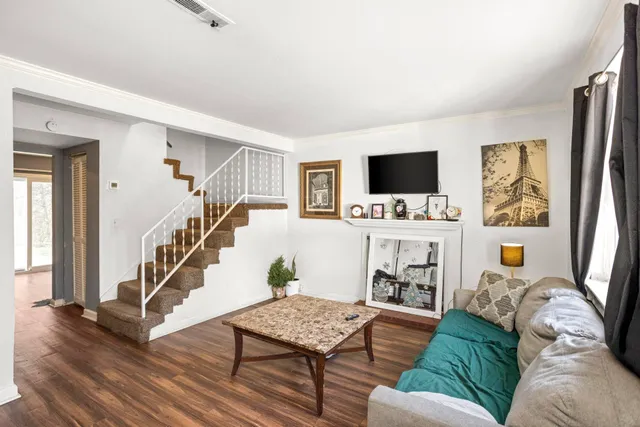 a living room with furniture and a flat screen tv with wooden floor