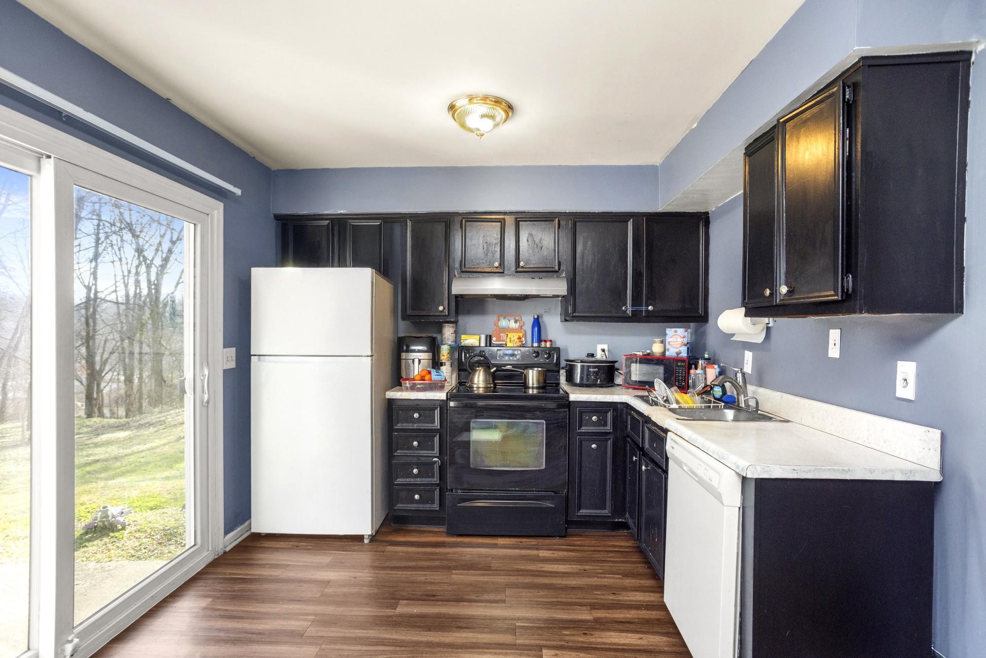 208 Leeshan Court Antioch, TN 37013 - Photo 7 of 31 a kitchen with a refrigerator a stove top oven and a sink with wooden floor