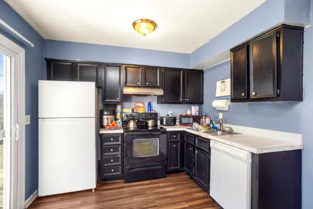 a kitchen with a sink a refrigerator a microwave and cabinets