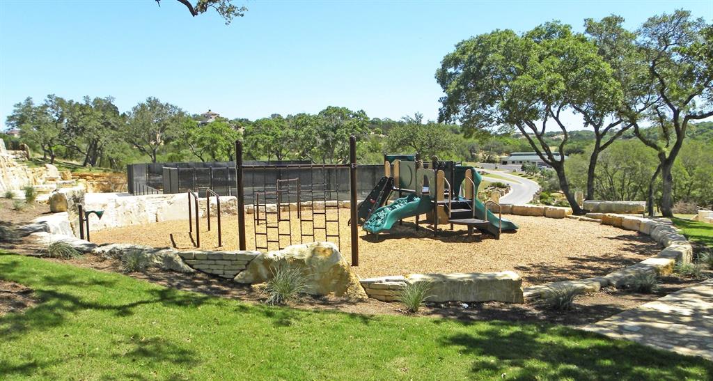 1765 Rowdy Loop, Unit 47 Leander, TX 78641 - Photo 39 of 39 Mature trees frame a neighborhood play structure surrounded by natural stone retaining walls.