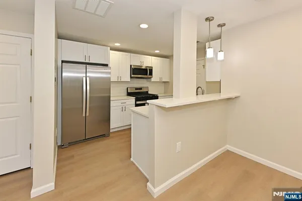 a kitchen with stainless steel appliances a refrigerator and a stove