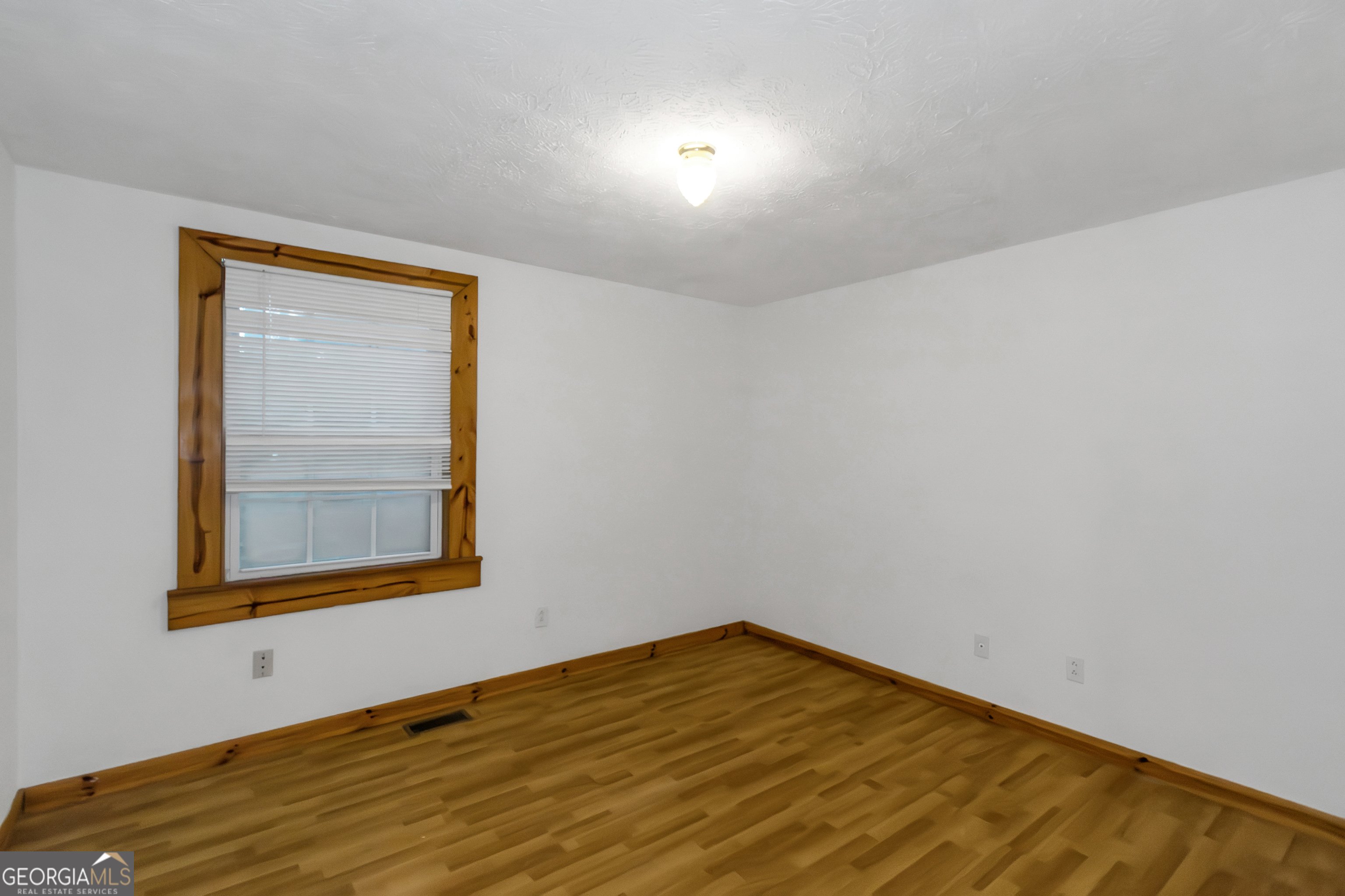 7600 Suwannee Court Jonesboro, GA 30236 - Photo 15 of 35 a view of an empty room with wooden floor and a window